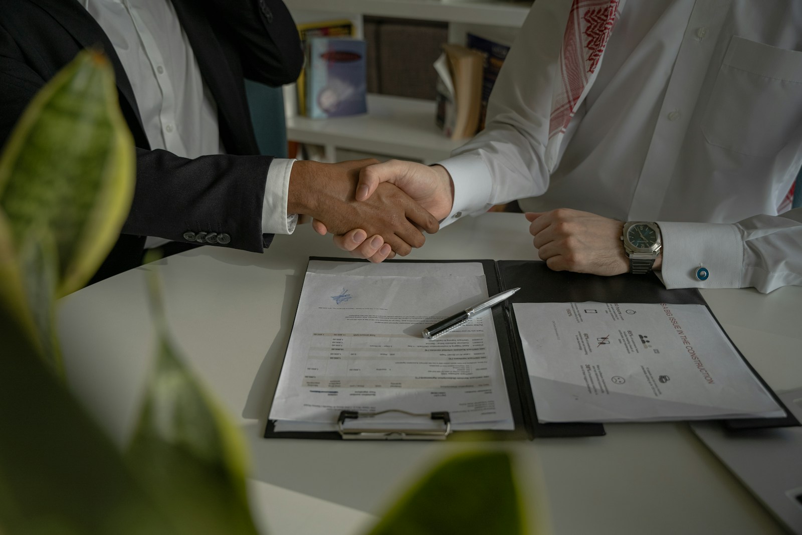 two people shaking hands over a piece of paper, surety bonds